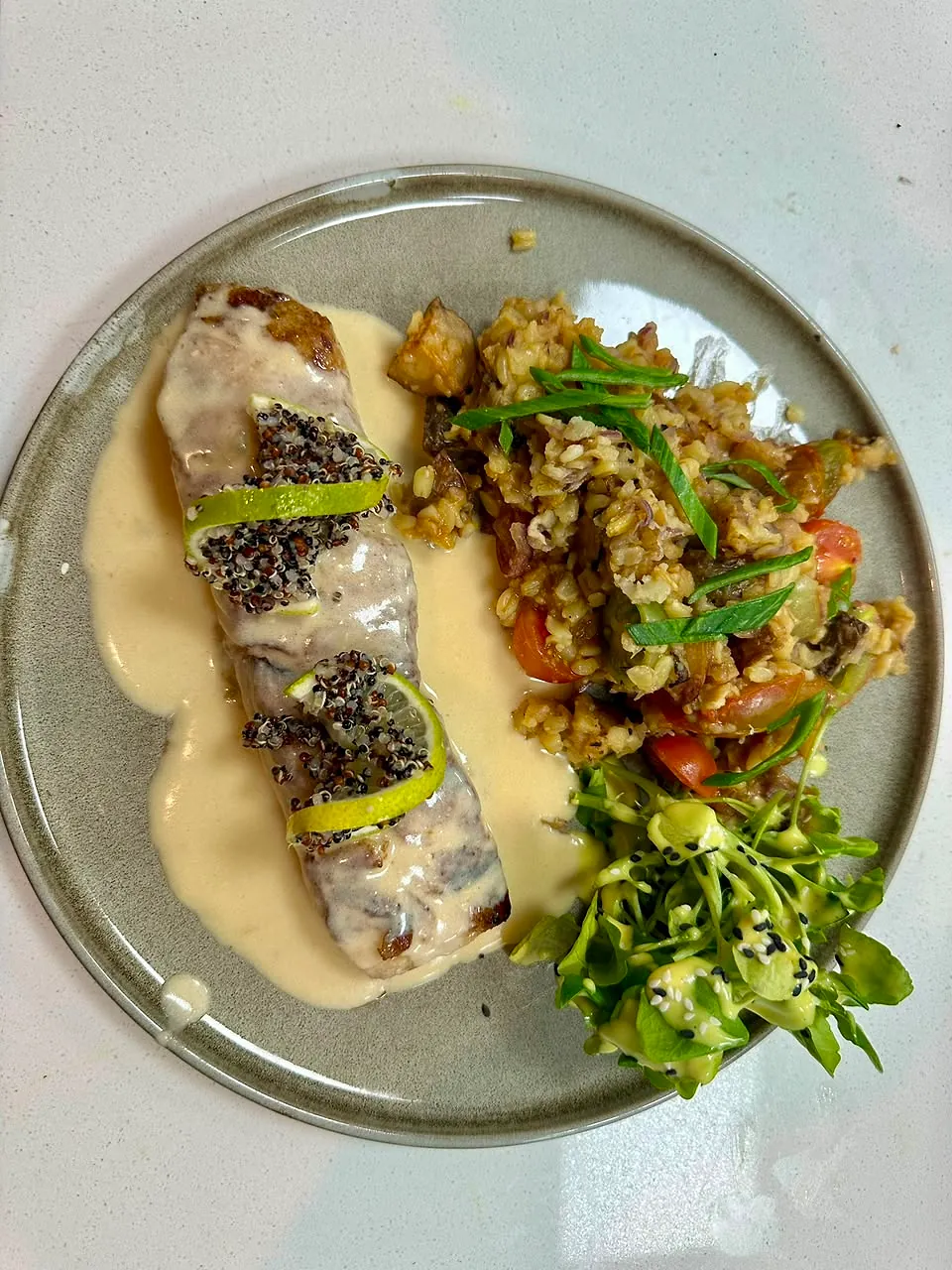 Plato de pescado con salsa cremosa y guarnición, visto desde arriba